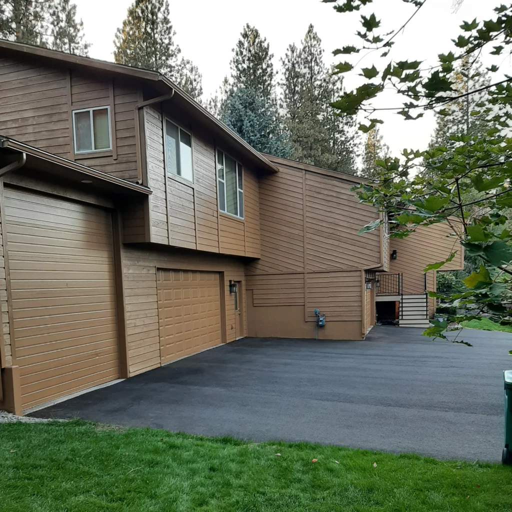 Beautifully renovated wooden home exterior with a fresh coat of brown paint, showcasing Coca Construction’s exterior home improvement services.