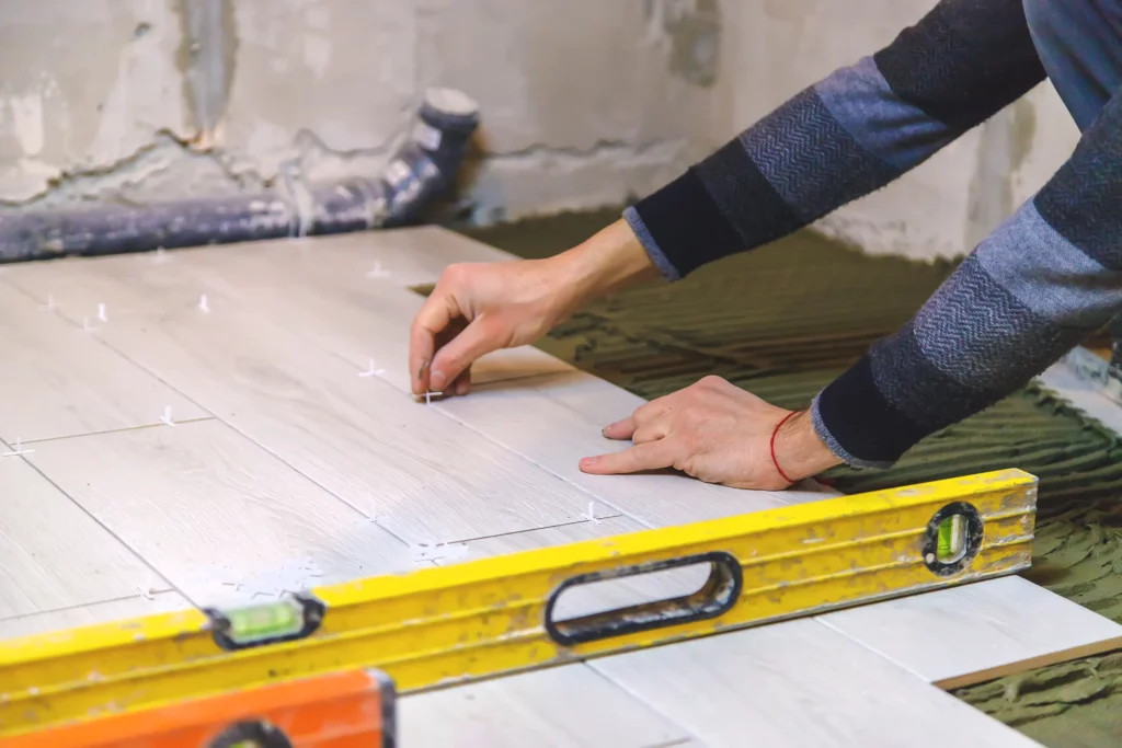 construction worker installing floor tiles