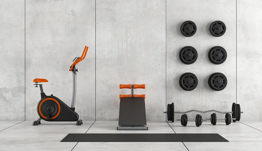 Home gym setup in a finished basement with exercise equipment against a concrete wall, showcasing Coca Construction's basement finishing work.