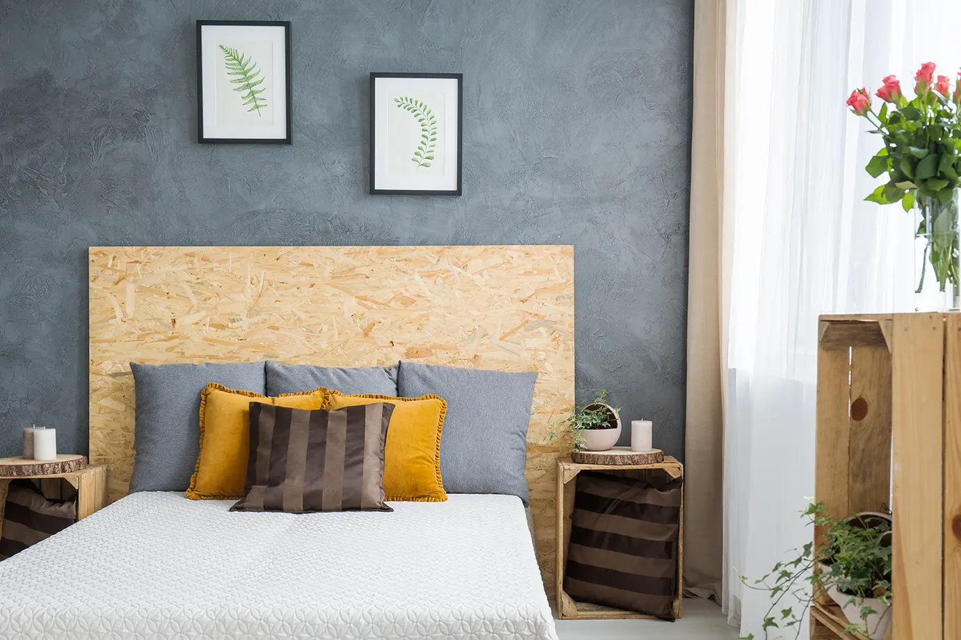 Cozy and stylish bedroom setup with a wooden headboard and decorative pillows, showcasing a finished basement space.