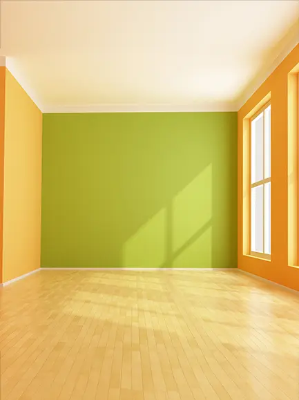 Brightly painted empty room with green and orange accent walls and large windows.