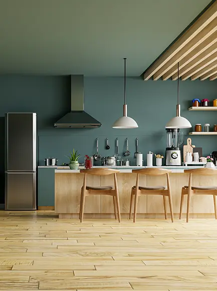 Modern kitchen with dark green walls, wooden flooring, and sleek cabinetry.