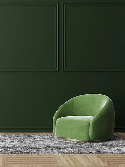 Dark green painted wall with a green modern chair on a textured rug.