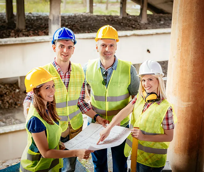 Team of four general contractors reviewing blueprints on a construction site in Spokane