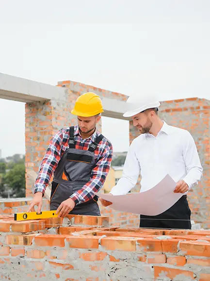 General contractor and builder reviewing construction plans at a brickwork site